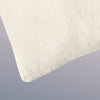 A closeup image of the Organic Pillow on a blue background