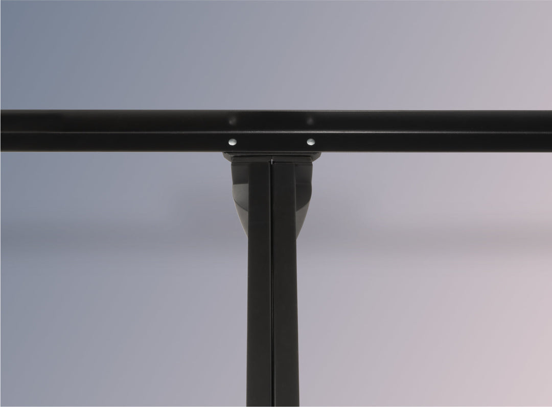 Close-up of a black metal bed frame on a gray background