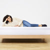 An image of the Waterproof Mattress Protector with a woman laying on top of a mattress