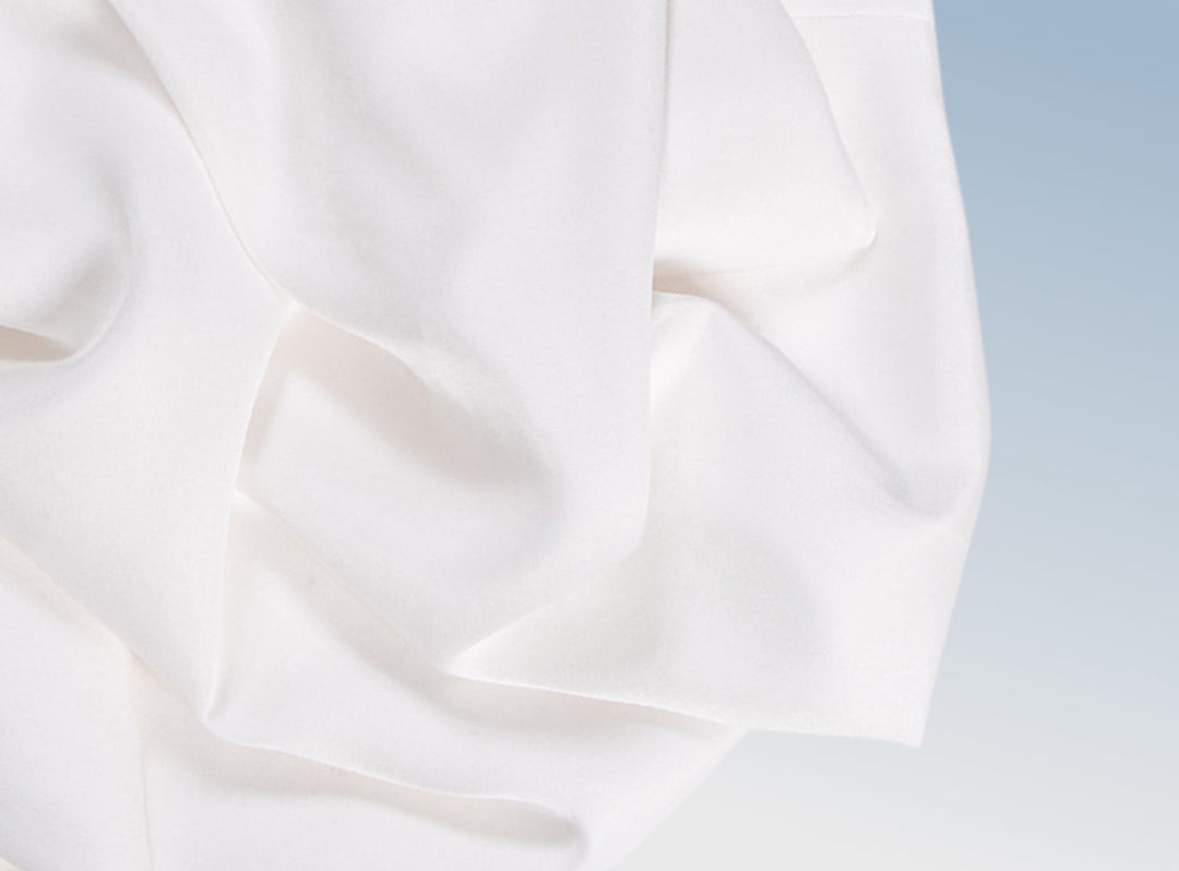 A closeup of the Tencel Sheet Set on a blue background