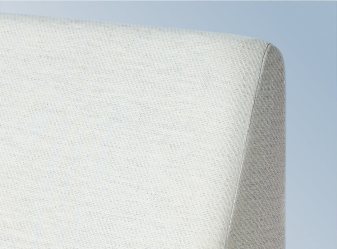 A closeup image of the Helix Wedge Pillow on a blue background
