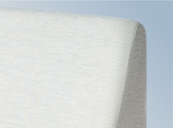 A closeup image of the Helix Wedge Pillow on a blue background