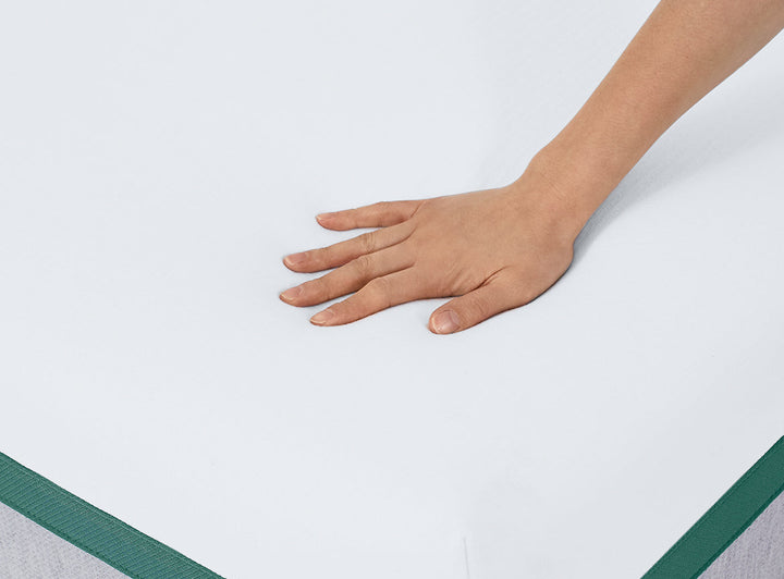 Hand pressing down on the firm Helix Twilight Mattress