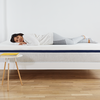 Woman lying on Helix Mattress on Helix White Wood Frame